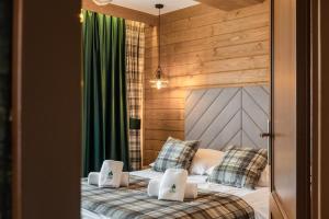 2 łóżka pojedyncze w pokoju z drewnianymi ścianami w obiekcie Leśne Apartamenty w mieście Białka Tatrzanska