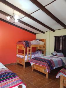 a bedroom with two bunk beds and orange walls at HOTEL MIL ESTRELLAS-TOROTORo in Torotoro +30 photos