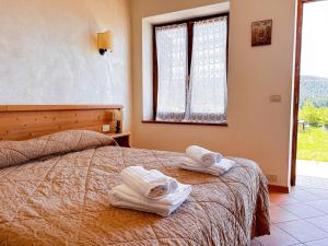 um quarto com toalhas numa cama com uma janela em Hotel Ristorante La Baitina em Asiago