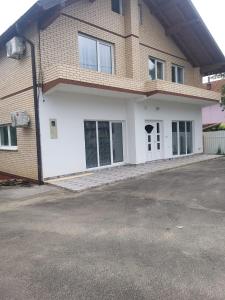 a house with white doors and a driveway at Privatna kuca- Malina in Visoko