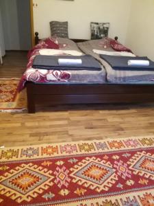 1 dormitorio con 2 camas y alfombra en el suelo de madera en Privatna kuca- Malina en Visoko