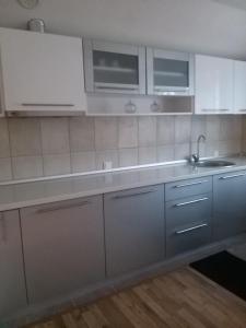 una cocina con armarios blancos y fregadero en Privatna kuca- Malina en Visoko