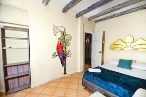 a bedroom with a parrot painting on the wall at Casa Hotel Terraza del Cabrero in Cartagena de Indias