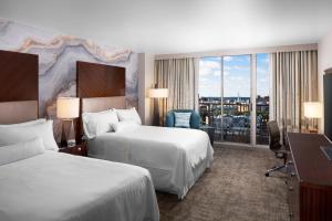 a hotel room with two beds and a desk at The Westin Savannah Harbor Golf Resort & Spa in Savannah