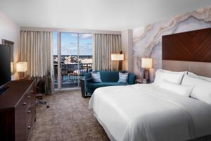 サバンナにあるThe Westin Savannah Harbor Golf Resort & Spaの大きなベッドとソファが備わるホテルルームです。