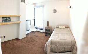 un dormitorio con una cama y una silla en CasaParque Mendoza, en Mendoza