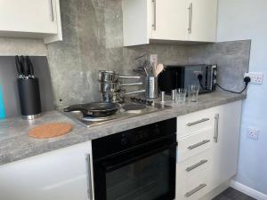 a kitchen with a stove and a microwave at Bottesford Apartments in Brumby