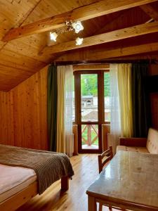 1 dormitorio con cama y ventana grande en Girskiy Prutets, en Bukovel