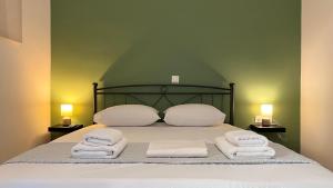 a bed with white towels on it with two lamps at Athenian Vintage Style 2 bdr apartment in Athens