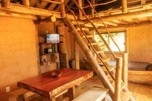 uma mesa de madeira num quarto com uma escada em Cabana Africana em Imaruí