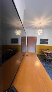 duży drewniany stół w pustym pokoju z oświetleniem w obiekcie Athenian Vintage Style 2 bdr apartment w Atenach
