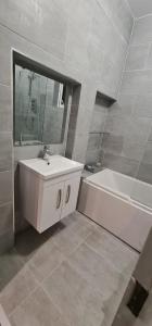 a bathroom with a sink and a tub and a mirror at Spacious large Room In Nottingham 005 in Nottingham