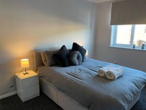 a bedroom with a bed with two towels on it at Bottesford Apartments in Brumby