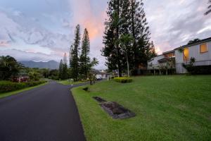 a street in a residential neighborhood with trees and a house at Makai Club Resort in Princeville