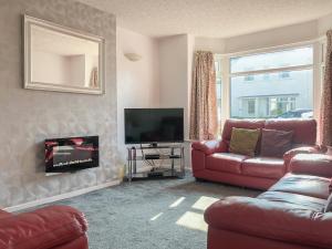 a living room with a red couch and a television at Wendover in Keswick