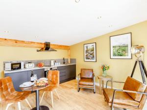 a kitchen and living room with a table and chairs at Rhosyn - Uk40260 in Llangadfan