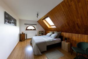 a bedroom with a bed with wooden walls and a window at L'Ermitage in Jalhay