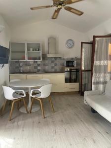 a kitchen with a table and chairs and a couch at Casa vacanze a tre minuti a piedi dal mare IUN R1932 in Forte Village