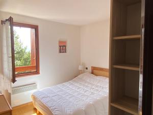 um quarto branco com uma cama e uma janela em Le Cantou - cocon chaleureux em Font Romeu Odeillo Via