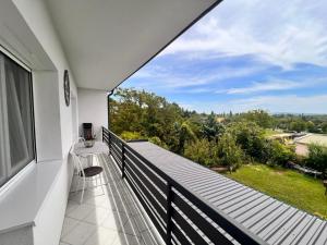 een balkon met uitzicht op een tuin bij Bem Apartman in Gyenesdiás