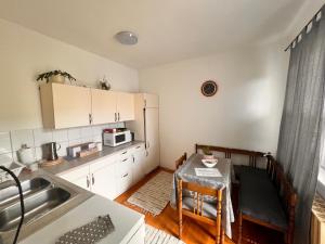 una pequeña cocina con mesa y fregadero en Bem Apartman, en Gyenesdiás