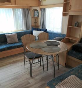 sala de estar con mesa, sillas y sofá en Domki holenderskie ,, Latający Holender", en Dębki