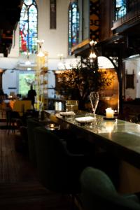 a restaurant with a bar with glasses and a candle at Boutiquehotel The Church in Arnhem