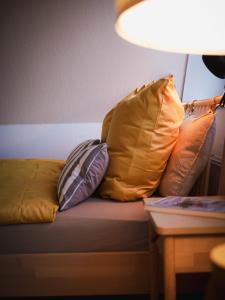 eine Gruppe Kissen auf einer Couch mit einer Lampe in der Unterkunft Gemütliche Oase in Detmolder City in Detmold