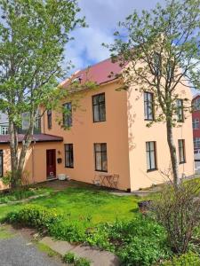 a large house with a yard in front of it at Beautiful apartment in the heart of Reykjavik in Reykjavík