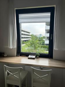 zwei Stühle vor einem Fenster mit Aussicht in der Unterkunft Bronowice in Krakau