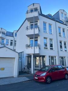 a red car parked in front of a building at Ruhiges Designer Apartment in Zentrum & Rheinnähe in Bonn
