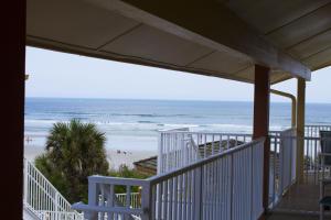 uma vista para a praia a partir do alpendre de uma casa de praia em New Smyrna Waves by Exploria Resorts em New Smyrna Beach