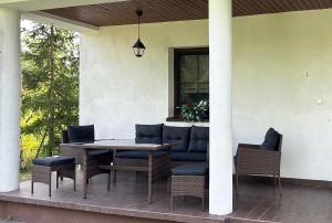 eine Terrasse mit einem Tisch und Stühlen auf einer Veranda in der Unterkunft Mazurskie Siedlisko Langen in Mrągowo