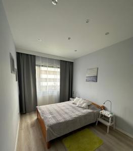 una camera da letto con un letto con un tappeto verde e una finestra di Bronowice a Cracovia