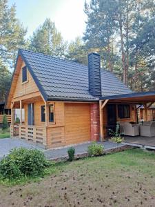 a log cabin with a black roof at Warta House - Domek z kominkiem nad Wartą in Prusicko