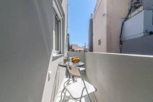 un pequeño balcón con una mesa y una silla en un edificio en Modern & Stylish flat for friends & couples en Heraclión