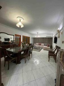 - un salon avec une table, des chaises et un canapé dans l'établissement Comfort & Relax at Maadi, au Caire