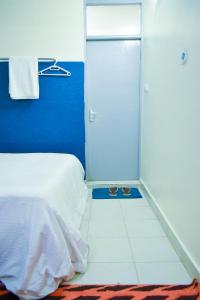 een slaapkamer met een wit bed en een blauwe muur bij Lilly Nest Studio in Nairobi
