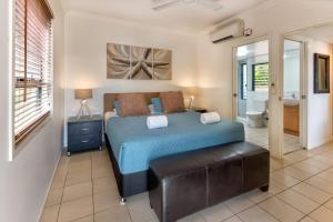 1 Schlafzimmer mit einem großen Bett und einem Badezimmer in der Unterkunft Escape to Paradise at Oasis 1, a 2BR Central Hamilton Island Apartment with Buggy! in Hamilton Island