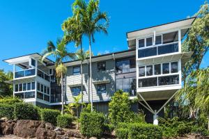 una imagen de un edificio de apartamentos con palmeras en Escape to Paradise at Oasis 1, a 2BR Central Hamilton Island Apartment with Buggy! en Isla Hamilton