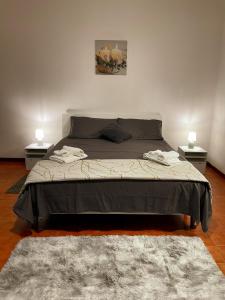 1 dormitorio con 1 cama grande y 2 mesitas de noche en Arena Maroncelli Rooms en Verona