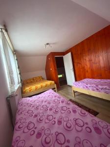 una camera con 2 letti e lenzuola viola di Cabana veverita a Sîntimbru-Băi