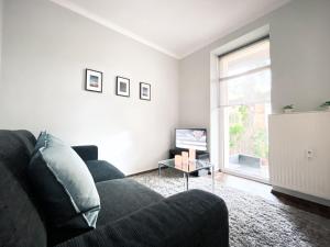 a living room with a couch and a tv at Gemütliche Ferienwohnung fußläufig am Markkleeberger See in Markkleeberg