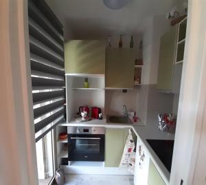 uma pequena cozinha com armários brancos e uma escadaria em UBAYE.MEXICO em Barcelonnette