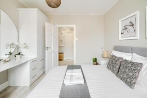 een witte slaapkamer met een bed en een badkamer bij Alfama Garden in Grudziądz