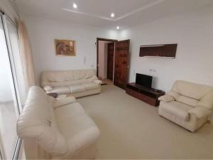 ein Wohnzimmer mit 2 Sofas und einem TV in der Unterkunft Luxurious appart Sousse chat meriem with sea view in Sousse