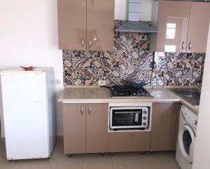 eine Küche mit einem Herd, einer Spüle und einem Kühlschrank in der Unterkunft Luxurious appart Sousse chat meriem with sea view in Sousse