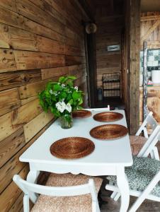 a white table with four chairs and flowers on it at Pod Aniołem in Świerzawa