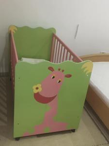 a baby crib with a cow pillow on it at Luxurious appart Sousse chat meriem with sea view in Sousse