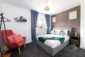 a bedroom with a bed and a red chair at Luke Stays Hill Crest Esh Durham in Durham